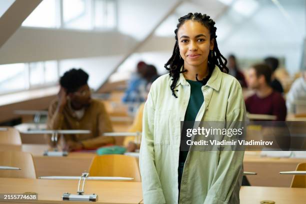 porträt einer hübschen studentin, die im klassenzimmer steht - classroom-front-view stock-fotos und bilder