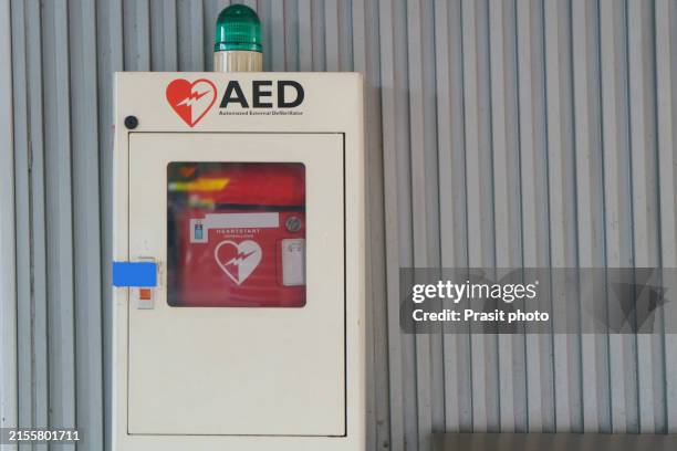 emergency readiness aed device mounted on tiled wall - defibrillator stock pictures, royalty-free photos & images