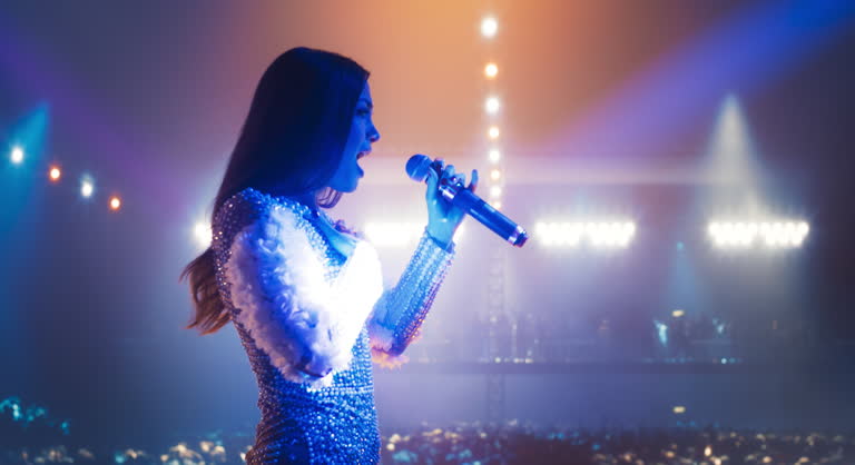 Female Pop Artist Performing Live Concert on Stage, Illuminated by ...