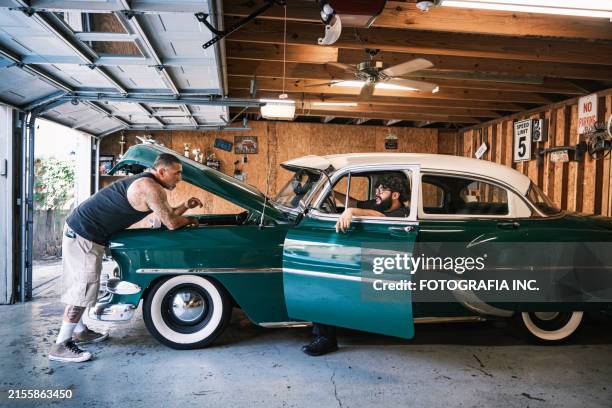mid adult latino male low rider enthusiast and his son working on the car - vintage audi stock pictures, royalty-free photos & images
