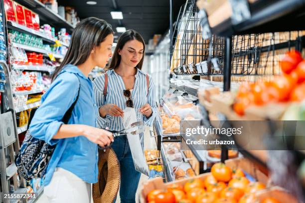 two female friends buying pastry at the supermarket in palma de mallorca in spain - spanish food stock pictures, royalty-free photos & images