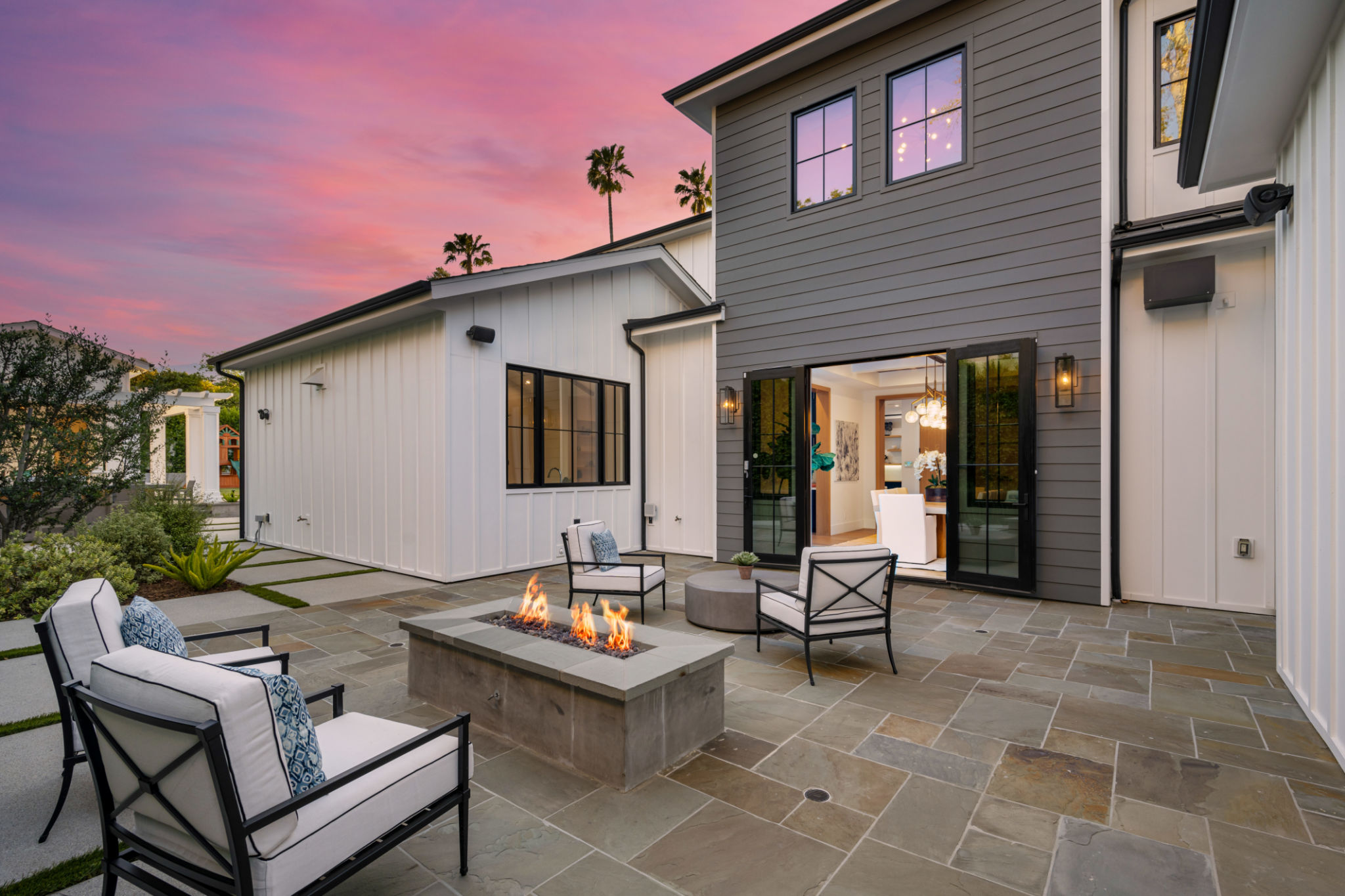 Outdoor seating area with a fire pit and chairs during sunset. Outdoor seating area with a fire pit and chairs during sunset.