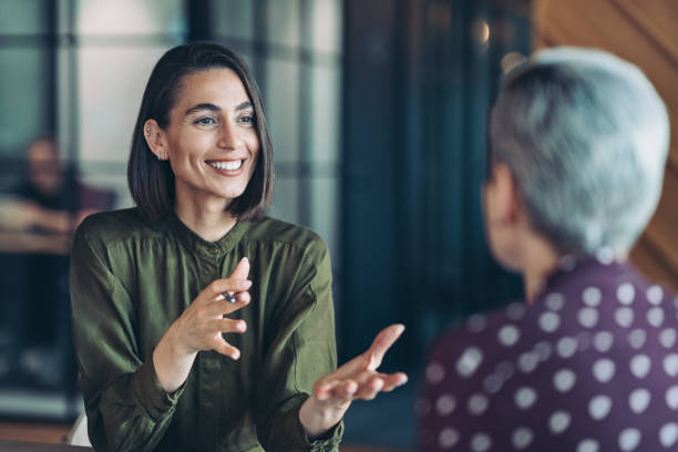 two businesswomen talking in the office - communication stock pictures, royalty-free photos & images