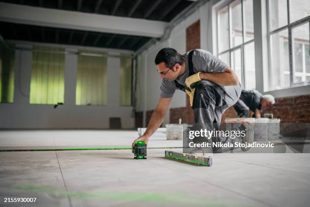 tiler placing ceramic tiles - waterpas stockfoto's en -beelden