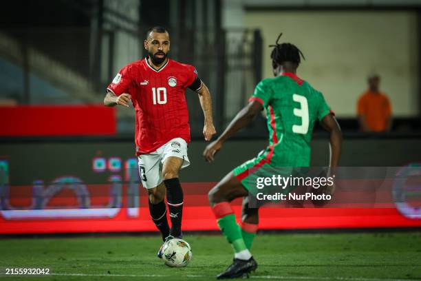 Mohamed Salah of the Egypt team is battling for possession with Mohamed Ouedraogo of the Burkina Faso team during a Men's World Cup qualifying...