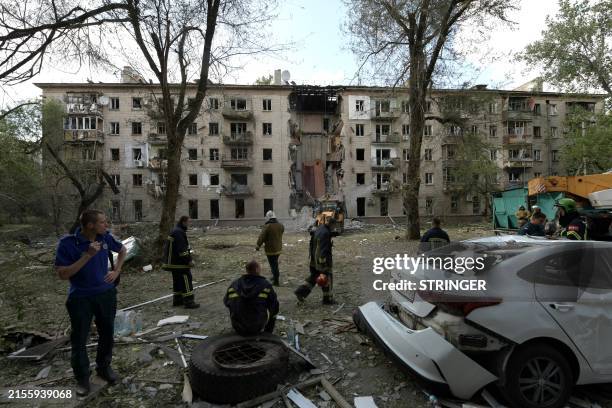 Rescuers work at the site of a missile attack in Lugansk, Russian-controlled Ukraine, on June 7 amid ongoing Russian-Ukrainian conflict. A Ukrainian...