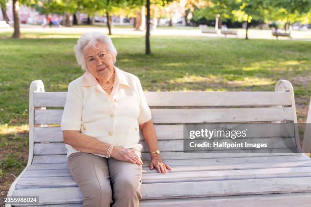 senior woman resting on park bench. elderly woman on walk, enjoying beautiful sunny weather. waiting for friend, family member. - park bench stock pictures, royalty-free photos & images