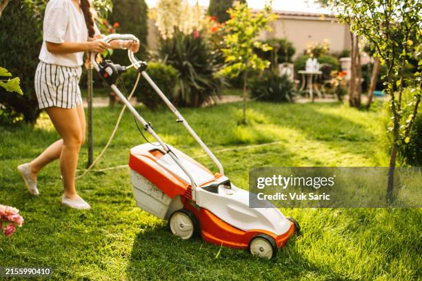 young woman mowing garden - mowing stock pictures, royalty-free photos & images