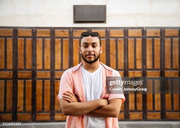 portrait of young man with arms crossed - arab people stock pictures, royalty-free photos & images