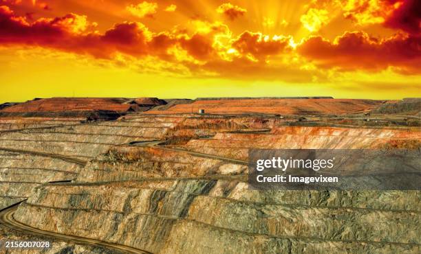dramatic yellow and orange sunset over a super pit gold mine, kalgoorlie, western australia, australia - mina abierta fotografías e imágenes de stock