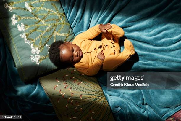 toddler lying on blue blanket under sunlight - zehenspitzen berühren stock-fotos und bilder
