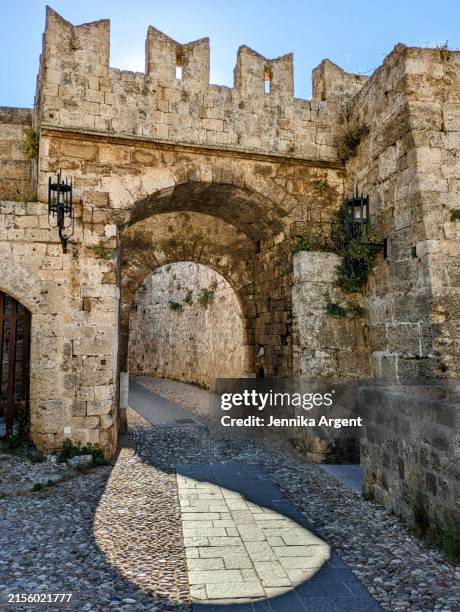 archway in stone fort wall with long shadow - old town stock pictures, royalty-free photos & images