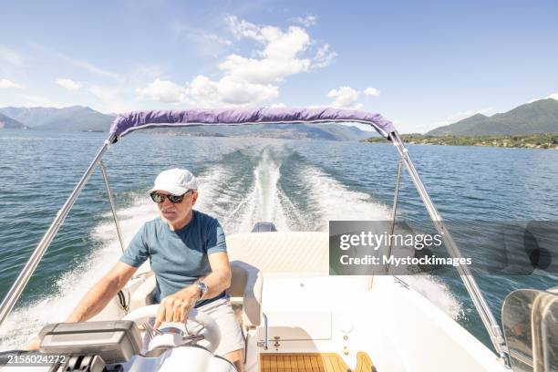 senior man cruising on a speedboat - ship captain wheel stock pictures, royalty-free photos & images