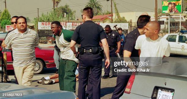 Los Angeles Police Department officers arrest four men who allegedly spray painted an OJ Simpson reference on the side of a building after Simpson...