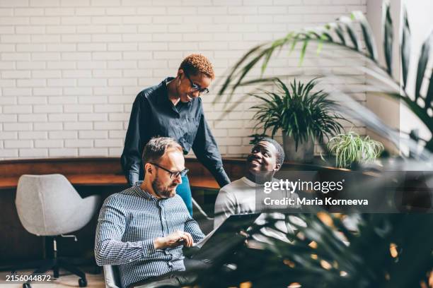 multi-ethnic coworkers discussing in office. - teamwork stock pictures, royalty-free photos & images