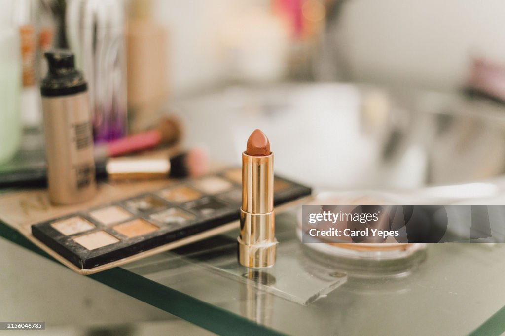 Lipstick on messy bathroom surface casting shadows