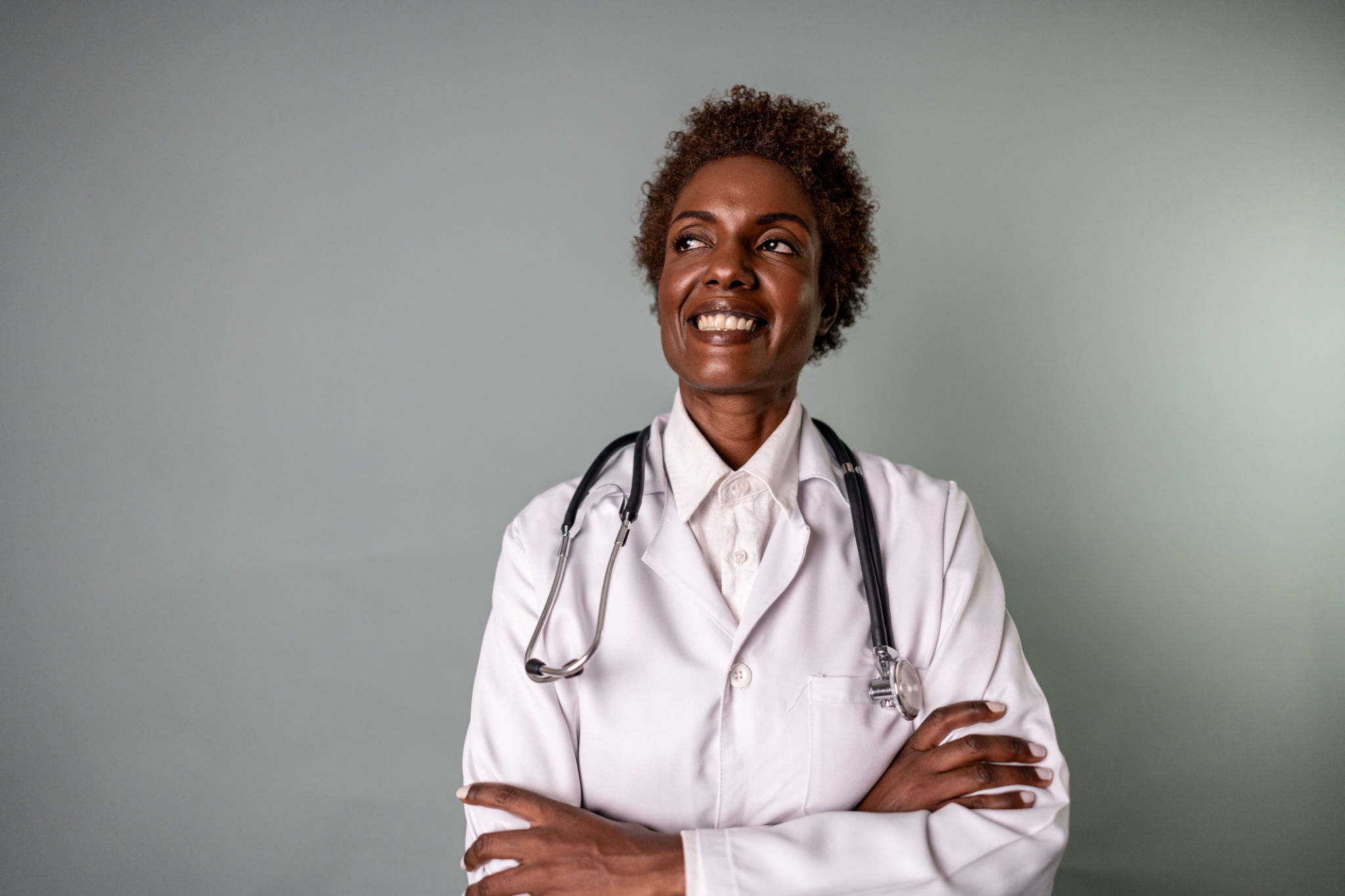 Mature doctor woman contemplating on a studio shot with gray background Mature doctor woman contemplating on a studio shot with gray background