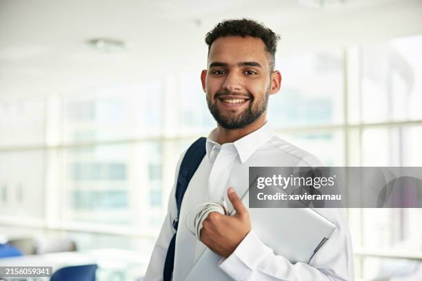 smiling male student holding laptop - arab people stock pictures, royalty-free photos & images