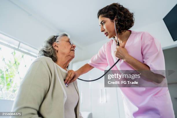 médico examinando a una anciana en un hogar de ancianos - condición fotografías e imágenes de stock