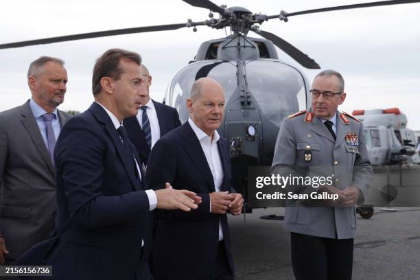 German Chancellor Olaf Scholz walks past an Airbus military helicopter as he chats with Airbus CEO Guillaume Faury at the 2024 ILA Berlin Air Show on...