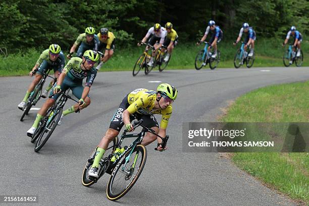 Team Bora's Slovenian rider Primoz Roglic wearing the overall leader's yellow jersey cycles with the pack of riders during the eighth and last stage...