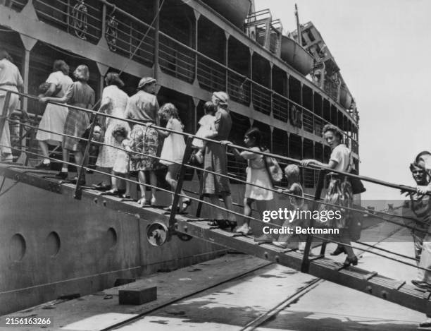 Women and children on the gangway as they board the ship transporting them from the 'Panama Canal Zone' detention camp in Panama, 6th April 1942....