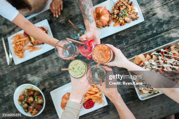 grupo de amigos disfrutando de comida chatarra vegana - comfort food fotografías e imágenes de stock