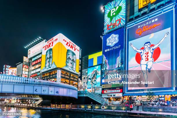 dotonbori district with bright colourful neon ads in osaka, kansai region, japan - osaka city stock pictures, royalty-free photos & images