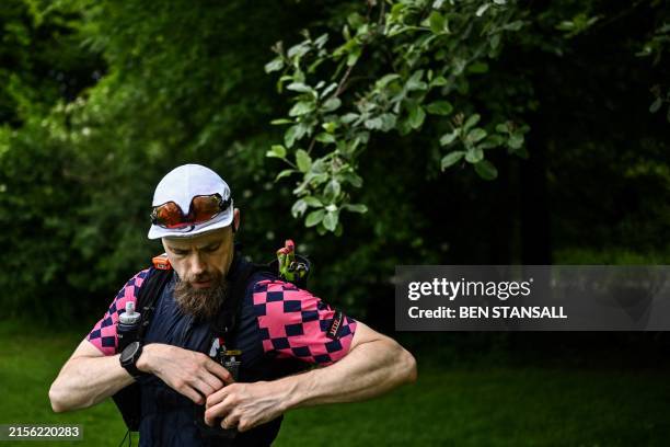 Runner stores food in his vest at a crew point on mile 22 of as he competes in the Centurion South Downs Way 100 ultramarathon, near Peterfield,...
