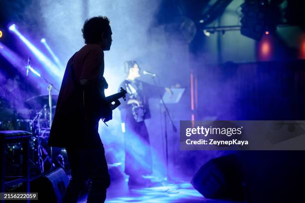 cantante vocale che si esibisce sul palco con luci colorate del palco. - musicista di musica pop foto e immagini stock
