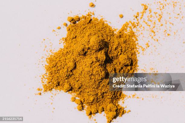 yellow spice on white background - colored powder stock pictures, royalty-free photos & images