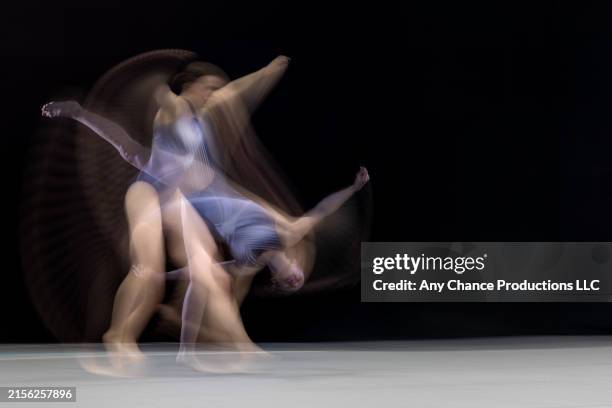 female gymnast performing a somersault during a floor exercise. - gymnast stock pictures, royalty-free photos & images
