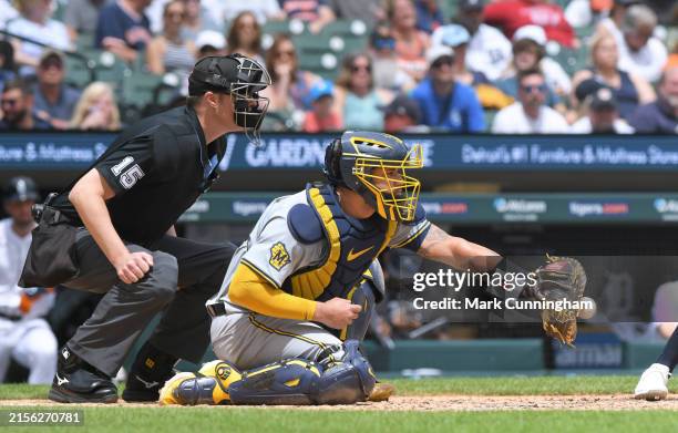 Major League umpire Clint Vondrak and Gary Sanchez of the Milwaukee Brewers crouch behind home plate and wait for a pitch during the game against the...