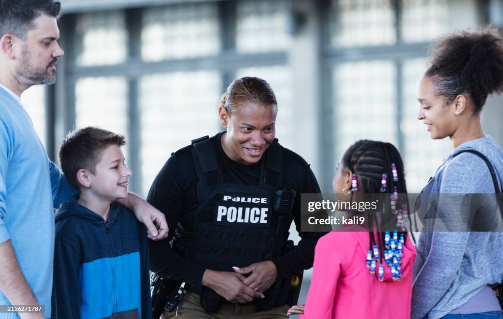Policewoman talking with parents and children outdoors