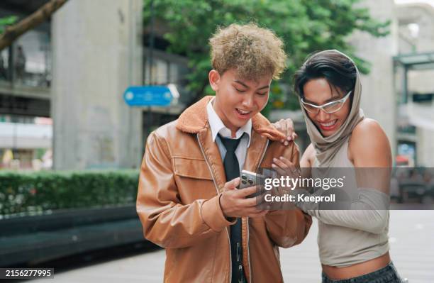 dos amigos usando un teléfono inteligente - estilo de vida alternativo fotografías e imágenes de stock
