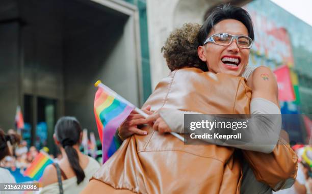 two friend celebrating in pride parade - stolz stock-fotos und bilder