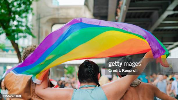 bandera del arco iris en el desfile del orgullo - desfile del orgullo gay fotografías e imágenes de stock