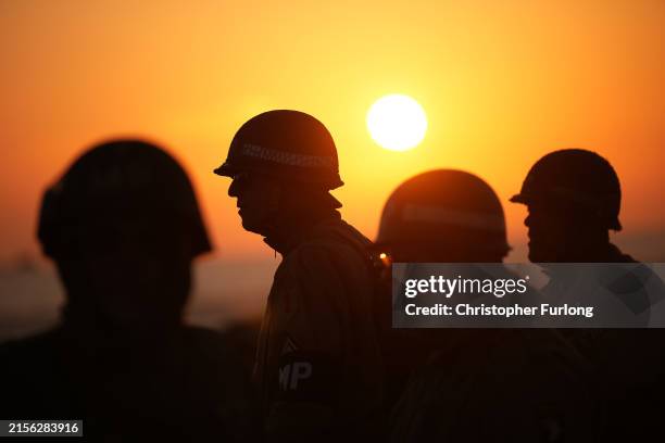 Military reenactors pay their respects on Gold Beach at sunrise on June 06, 2024 in Arromanches-les-Bains, France. June 6th is the 80th anniversary...