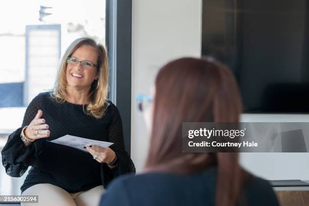 a female professional explains a concept to her colleagues during an educational session, serving as the instructor for the class. - financial literacy stock pictures, royalty-free photos & images