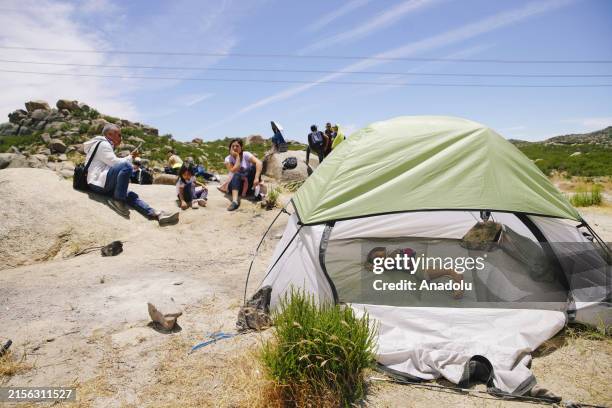Migrants sit as they wait to cross into the US from Mexico, days after President Biden signed an executive order to change border policy, on June 9...