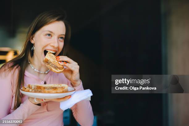 a young woman is enjoying a delicious sandwich. - white bread stock pictures, royalty-free photos & images