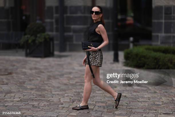 Dariia Prokopovych is seen wearing large black sunglasses in butterfly shape from Yves Saint Laurent, golden earrings in an organic round shape, a...