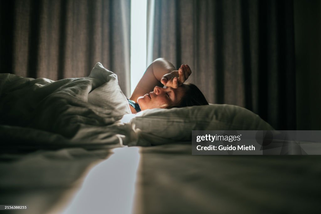 Woman awaking after sleeping well in a nice sleeping room.