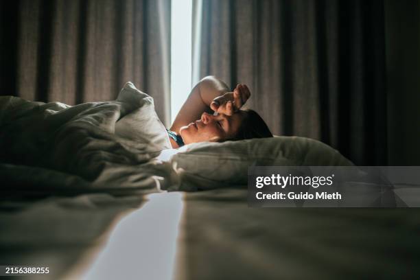 woman awaking after sleeping well in a nice sleeping room. - krankheit stock-fotos und bilder