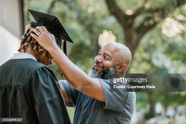 ayudando a su hijo con su gorra de mortero, un padre lo prepara para la graduación. - graduación fotografías e imágenes de stock