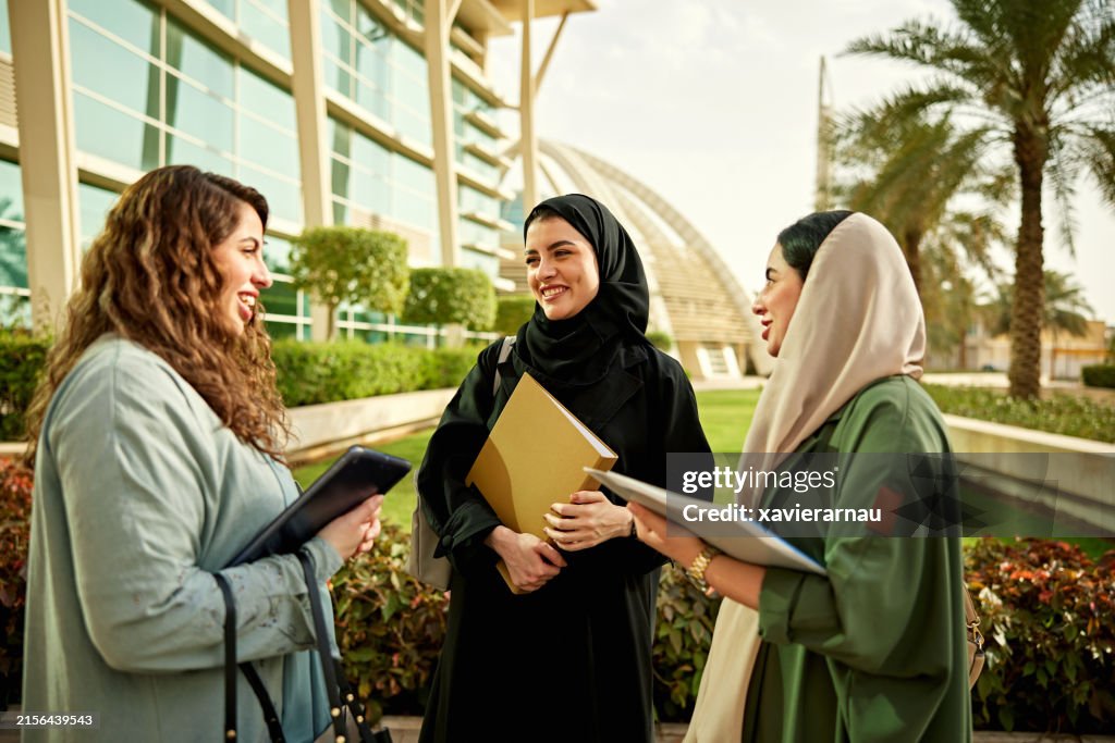 Mujeres saudíes hablando entre sí en el campus universitario