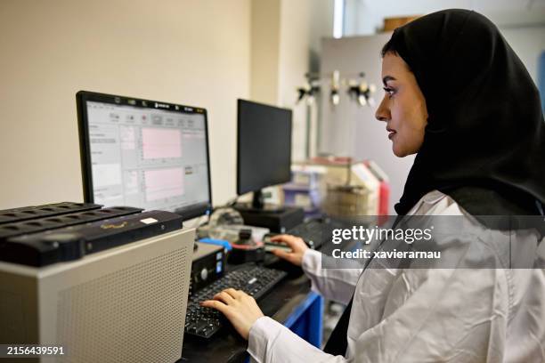 saudi female researcher using computer in science lab - cultura árabe imagens e fotografias de stock