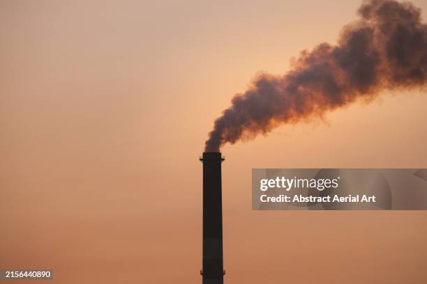 smoke stack polluting the atmosphere photographed at sunset, mount isa, queensland, australia - gaz à effet de serre photos et images de collection