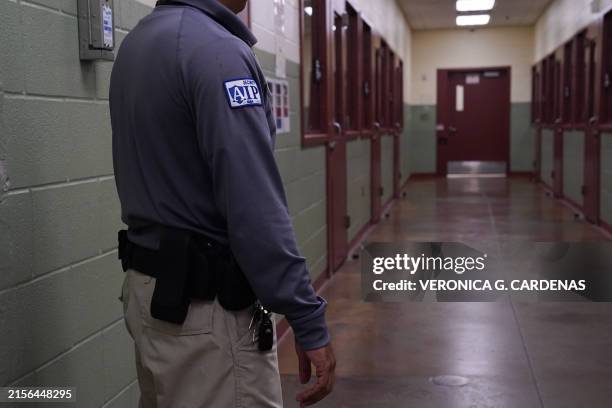 Security guard poses for a photo next to the group holding cells during a media tour of the Port Isabel Detention Center , hosted by U.S. Immigration...