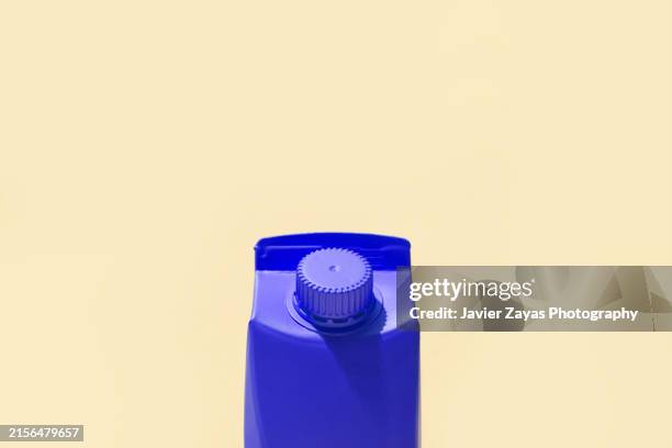 blue small milk or juice box on yellow background - juice box stock pictures, royalty-free photos & images